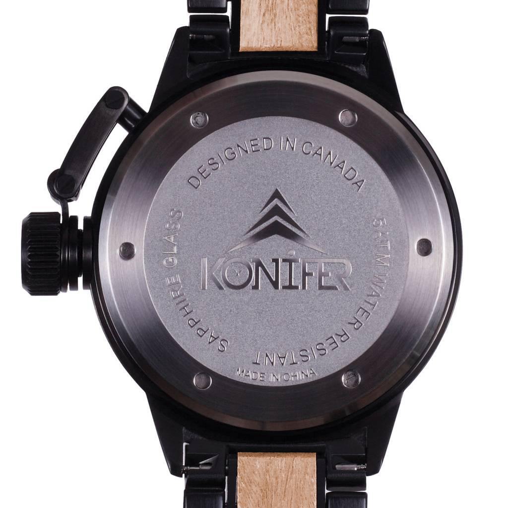 Montre en  metal noir mat et bois zebre a cadran rond. Vue arriere du cadran