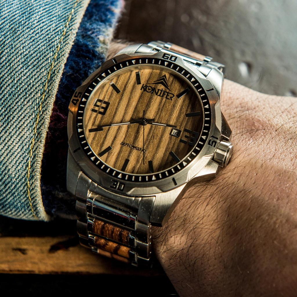 Montre en metal et en bois zebre a cadran rond. Sur poignet