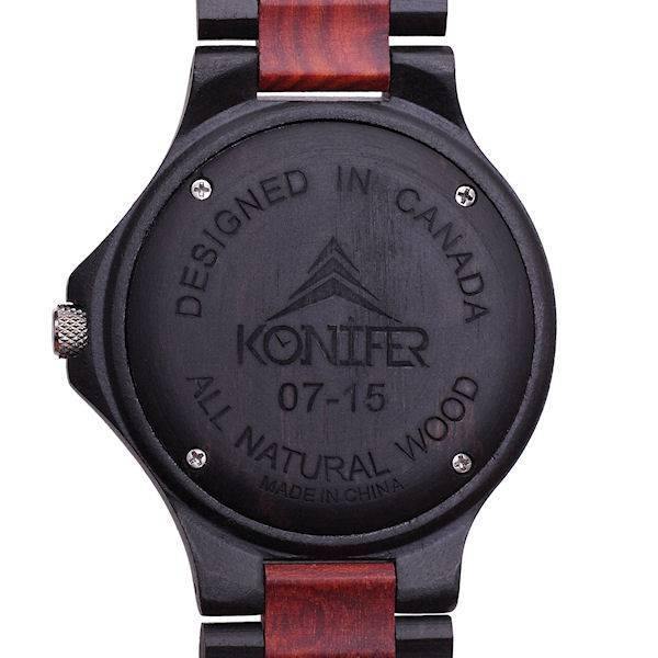 Montre en bois noir et rouge zebre a cadran rond. Vue arriere du cadran